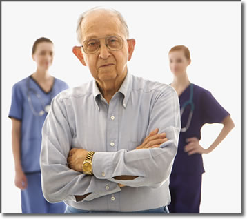 Photo of a depressed elderly man with medical persons behind