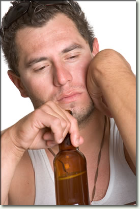 Photo of unshaven man drinking alcohol from a bottle