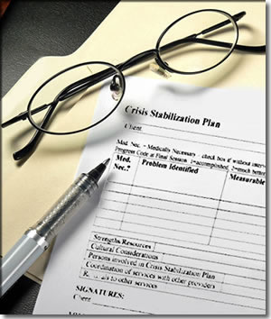 Photo of a Crisis Stabilization Plan on a desk with a pair of glasses and pen lying on top.