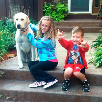 Photo of two DeafBlind children with a dog