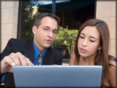 a buisness man meeting with a young lady at a computer