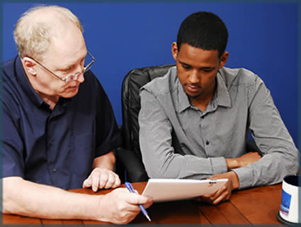 A Case Manager and Hassan looking over some papers