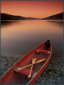 a boat on a lake at the sunset